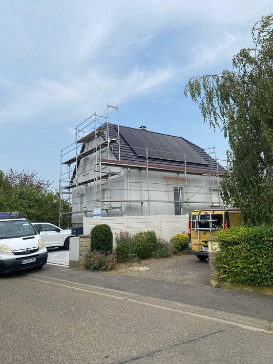 Maison individuelle sous echafaudage avec panneaux solaires poses en toiture, pres de Strasbourg