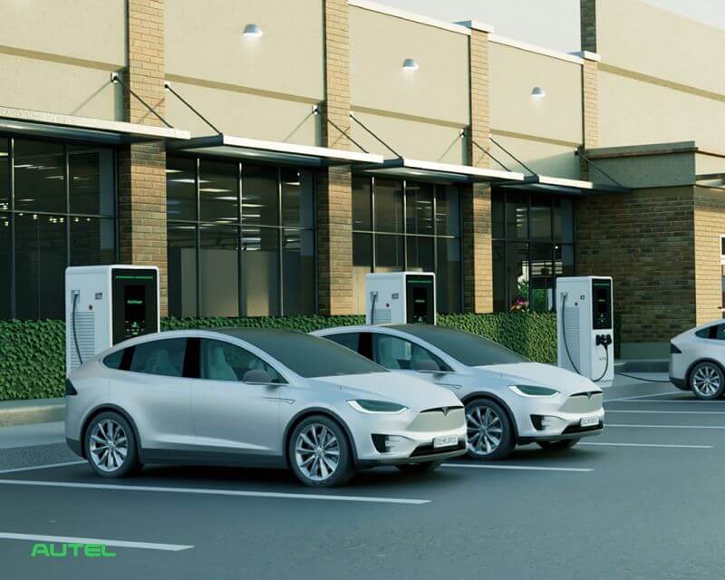Bornes de recharge rapide DC AUTEL devant un bâtiment tertiaire, deux véhicules électriques en charge